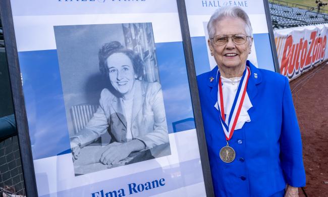 Elma Roane poses with her photo at induction ceremony