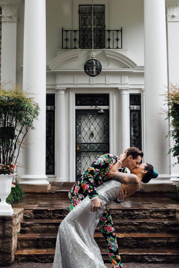 A bride and groom kiss in front of Elvis Presley's Graceland Mansion