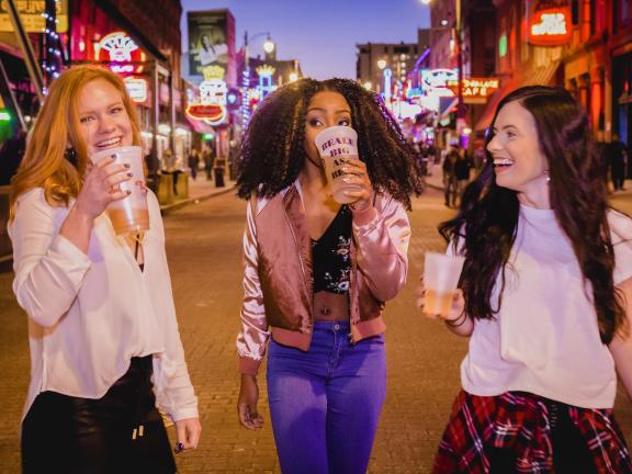 three girls drinking while walking down Beale street