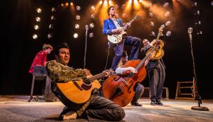 Performers on stage with guitars in a play at Playhouse on the Square.