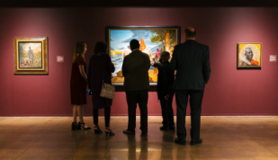 A group of visitors looking at a painting at the Brooks Museum of Art.